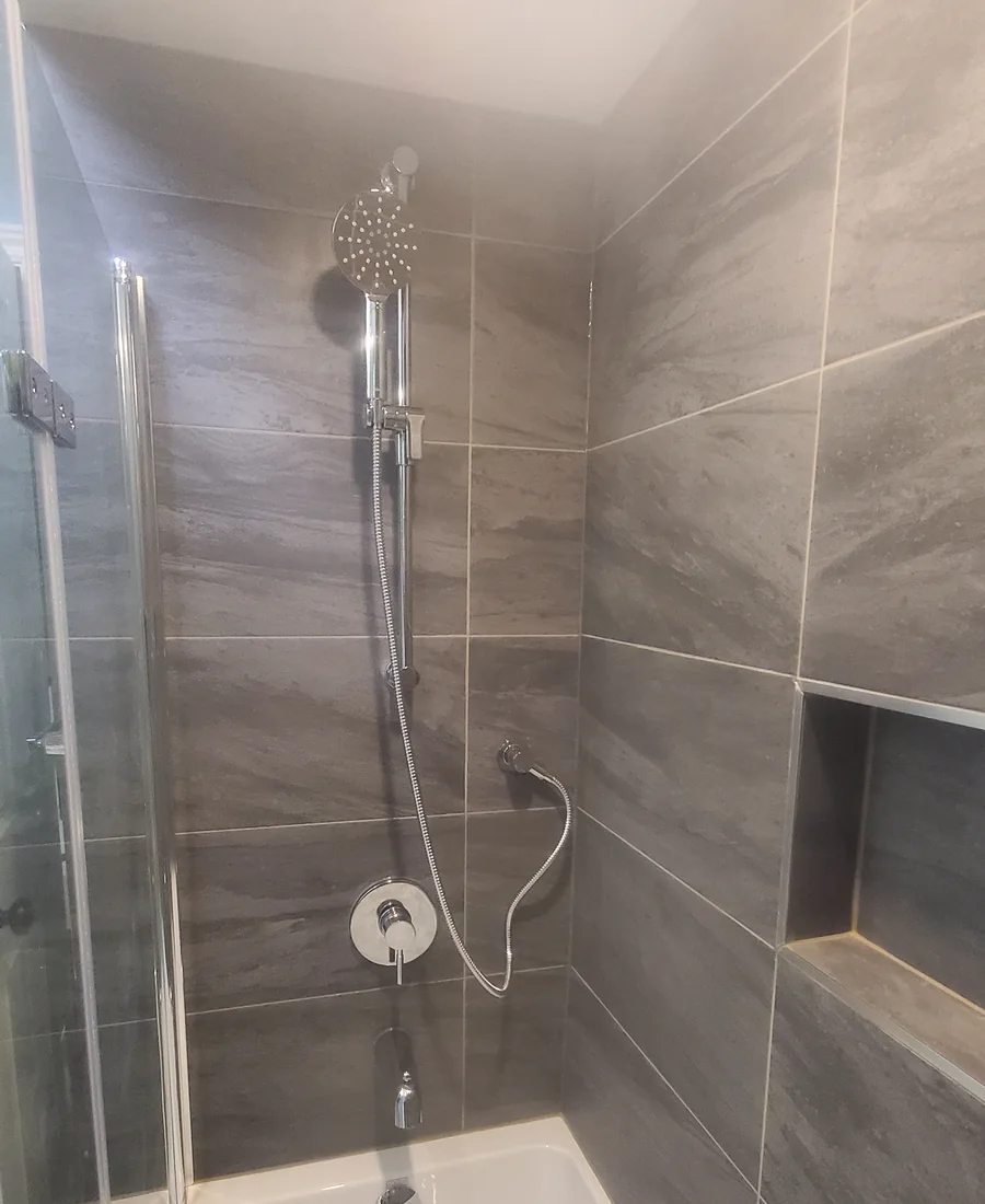 Bathroom shower renovation with glass enclosure and large-format tile